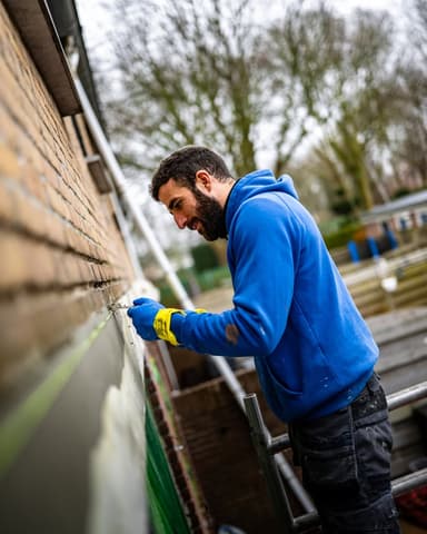 Vakman brengt conserveringsmiddel aan op metselwerk voorgevel in Nieuw-Beijerland