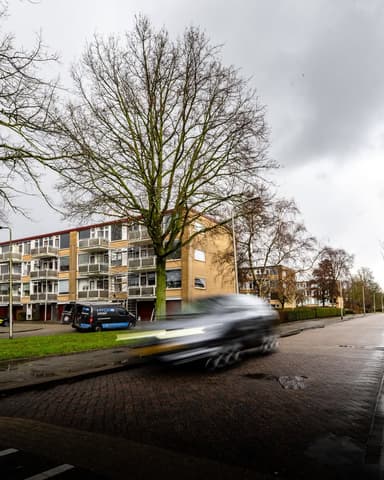 Twee medewerkers reinigen gevel vanuit hoogwerker bij appartement in Ridderkerk