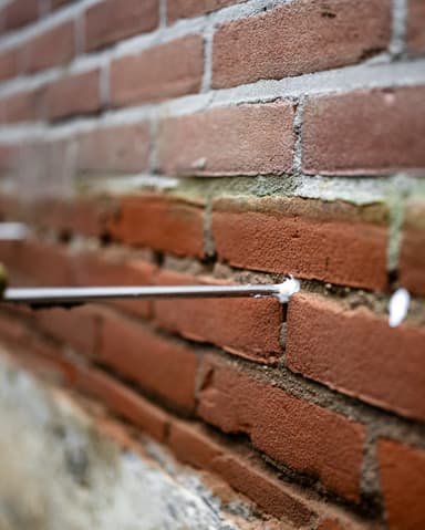 Twee vakmannen vullen injectiepistool met injectiemiddel bij project in Brielle