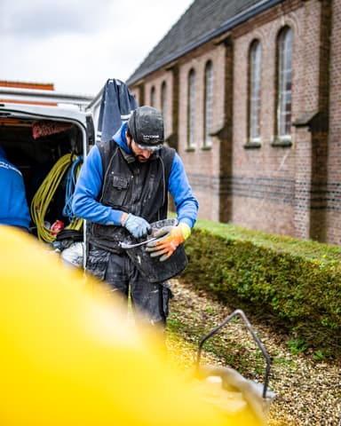 Medewerker bereidt gereedschap voor bij historische kerk in Tinte voor betonreparatie