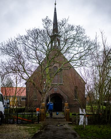 Portret vakman tijdens betonreparatiewerkzaamheden bij kerk in Tinte