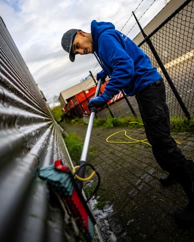 Close-up hogedrukreiniging van gegolfde gevelbeplating bij ABS Den Elzen in Zoetermeer