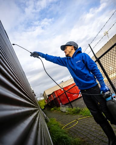 Gieten van conserveringsmiddel in drukspuit voor gevelbehandeling in Zoetermeer