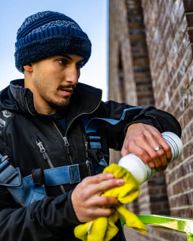 Medewerker reinigt aluminium kozijn met PreClean AL10 vanuit hoogwerker in Leiden