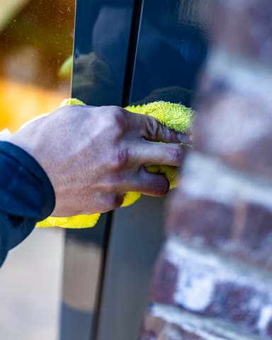 Kunststof kozijn poetsen met microvezeldoek voor coating bij kantoorpand in Leiden
