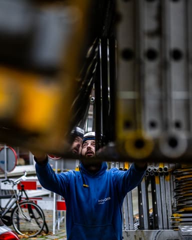 Kraan transporteert steigerpallet bij Rochussenstraat in Rotterdam door Hydro Groep
