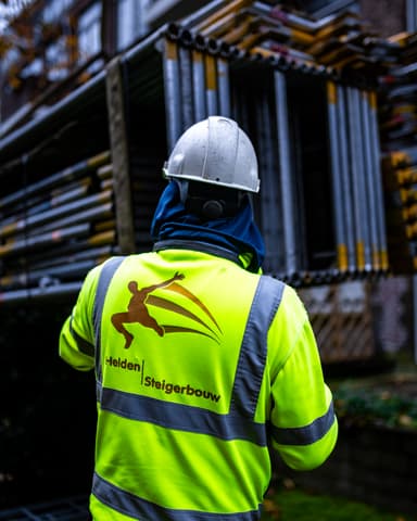 Steigerbouwer sorteert materiaal bij voorgevel appartement in Rotterdam