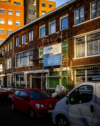 Vakman bevestigt stalen latei vanaf steiger bij woning in Vlaardingen