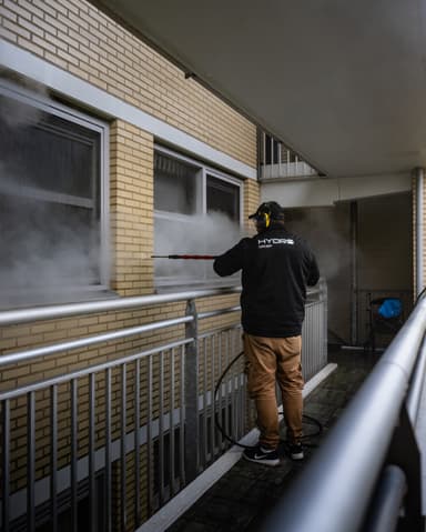 Hydro Groep medewerker reinigt gevel met SteamPlus vanaf galerij bij VvE Oostelijk Bastion Vlaardingen