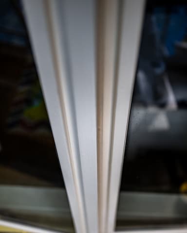 Schilder schuurt kozijn op steiger tijdens buitenschilderwerk aan woning in Rotterdam door Hydro Groep