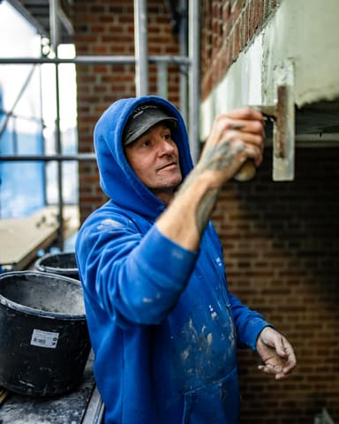 Vakman brengt reparatiemortel aan op latei tijdens betonreparatie in Rotterdam door Hydro Groep