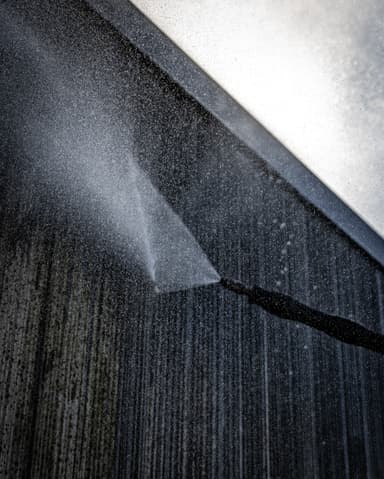 Medewerker reinigt gevelpaneel met SteamPlus op ladder bij VvE Biancaland in Den Haag