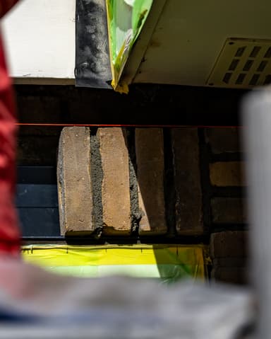 Hand plaatst nieuw spouwlood bij latei tijdens constructief onderhoud in Oostvoorne door Hydro Groep
