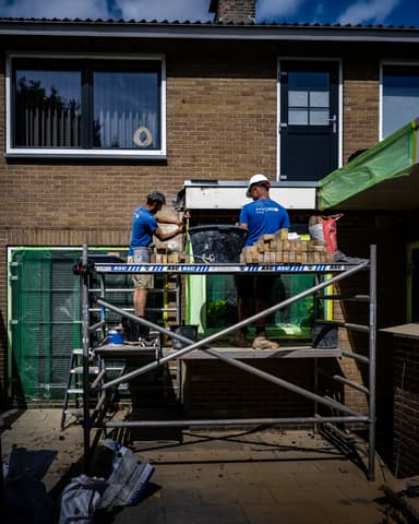 Vakman werkt voegwerk af bij zijgevel tijdens constructief onderhoud in Oostvoorne door Hydro Groep