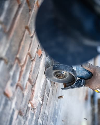 Close-up slijpschijf bij uitslijpen voegwerk tijdens conserveren metselwerk in Rotterdam door Hydro Groep