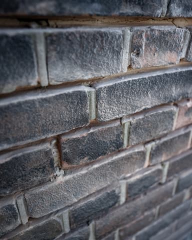 Vakman brengt nieuw platvol nagestreken voegwerk aan bij conserveren metselwerk in Rotterdam