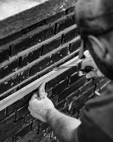 Twee vakmannen brengen nieuw snijvoeg voegwerk aan bij conserveren metselwerk in Rotterdam