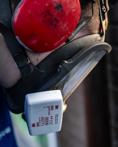 Medewerker hakt voegwerk uit op steiger aan voorgevel voor conserveren metselwerk in Sommelsdijk