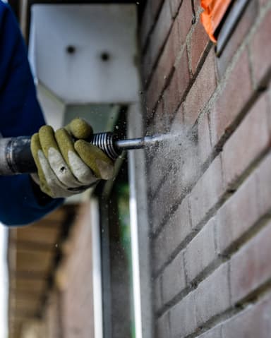 Close-up 3M adembeschermingsmasker met filters bij conserveren van metselwerk in Sommelsdijk