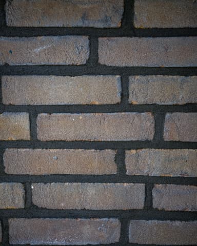 Medewerker repareert voegwerk bij raamkozijn op begane grond tijdens conserveren metselwerk Dordrecht