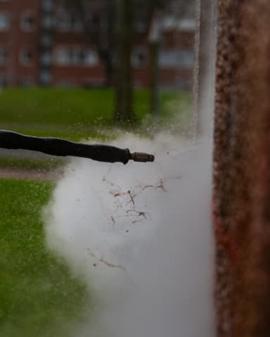Aanbrengen graffitiverwijderingsmiddel met kwast op metselwerk Stedin object Rotterdam Den Haag