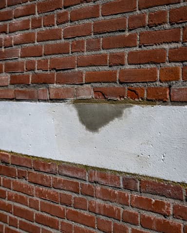 Close-up aanbrengen reparatiespecie op betonschade in gevel Meulemansflat Tilburg