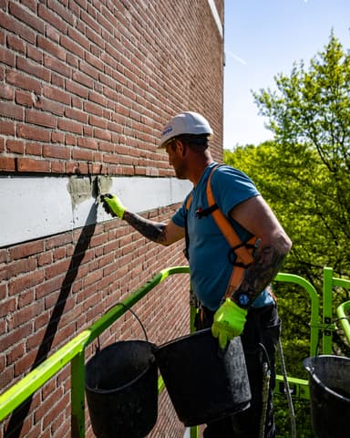Medewerker detecteert spouwankers met scanner op kopgevel bij betonreparatie Meulemansflat Tilburg