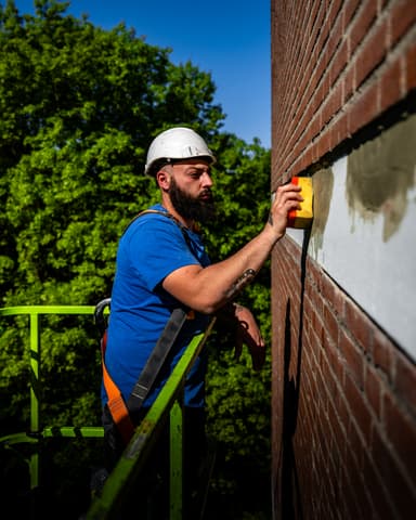 Beschadigde betonband in gevel voor aanvang betonreparatie Meulemansflat in Tilburg