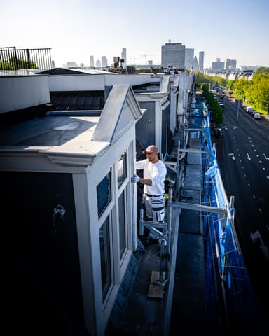 Medewerker meet ijzerwerk af met potlood voor verwijdering bij betonreparatie Residentie Raamweg Den Haag