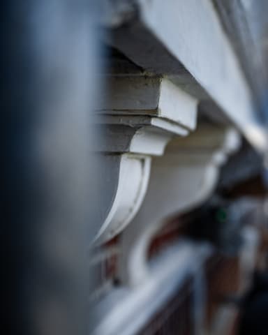 Medewerker voert schilderwerk uit aan dorpels op steiger bij Residentie Raamweg in Den Haag