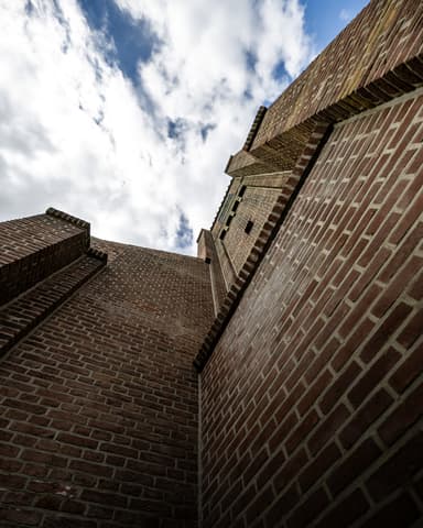 Medewerker werkt aan kerk voegwerk op steiger vanuit binnenzicht bij conserveren metselwerk Willemstad