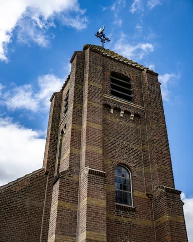 Kerktoren vanuit kikvorsperspectief met gedetailleerd metselwerk bij conserveren metselwerk Willemstad