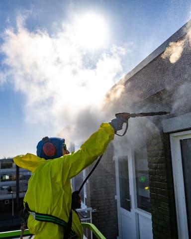Stoomlans reinigt hoekdetail metselwerk aan VvE-complex in Ridderkerk door Hydro Groep