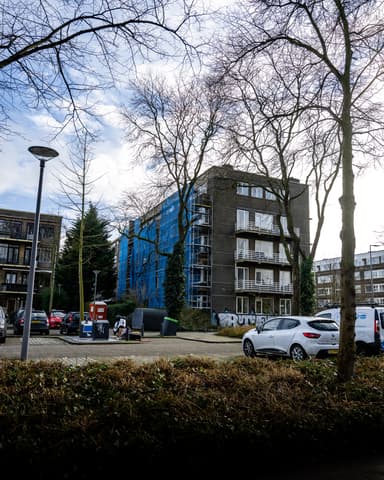 Vakman bereidt metselwerk op steiger voor balkoncoating in Rotterdam door Hydro Groep