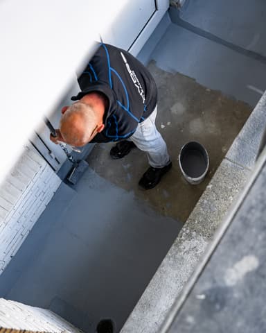 Detail aanbrengen vloercoating met roller op balkonvloer in Rotterdam door Hydro Groep