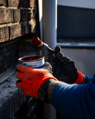 Aanbrengen menieverf bij kozijn en metselwerk in Rotterdam door Hydro Groep