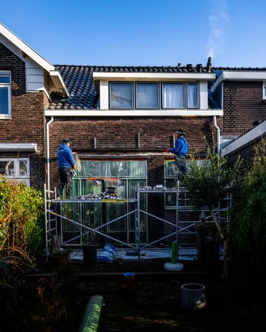Reinigen kozijnprofiel met spons na werkzaamheden in Rotterdam door Hydro Groep