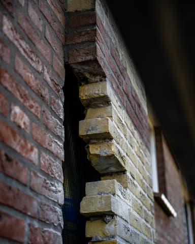 Vakman boort in metselwerk vanaf steiger in Capelle aan den IJssel door Hydro Groep