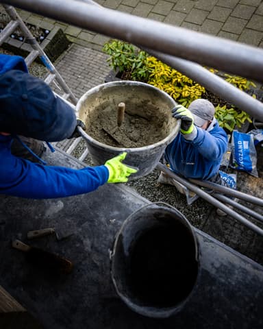 Voorgevel rijtjeshuis met steiger tijdens metselwerkzaamheden in Capelle aan den IJssel