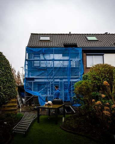 Vakman met gasmasker bereidt straalapparatuur voor in Rhoon tijdens conserveren metselwerk door Hydro Groep