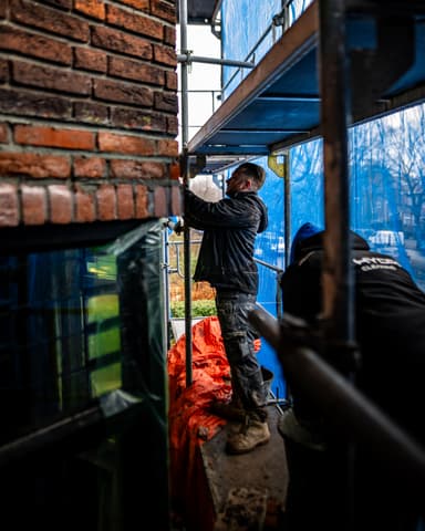 Hydro Groep steiger en bedrijfsbus bij voorgevel in Voorburg tijdens betonreparatie project