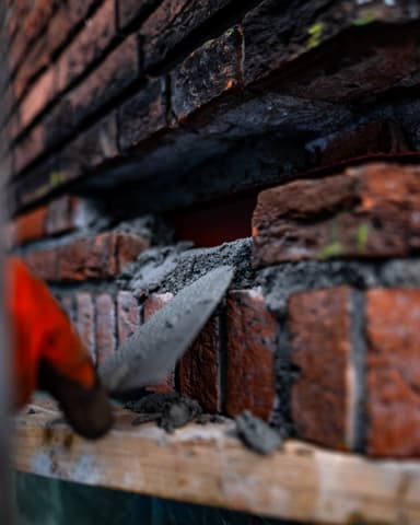 Medewerker werkt aan gevel op steiger bij raam in Voorburg tijdens betonreparatie door Hydro Groep