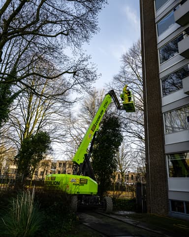 Medewerker met stoomlans in beschermkleding portret in Rotterdam tijdens conserveren metselwerk