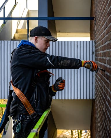 Overzicht conservering zijgevel flat vanuit hoogwerker in Rotterdam door Hydro Groep