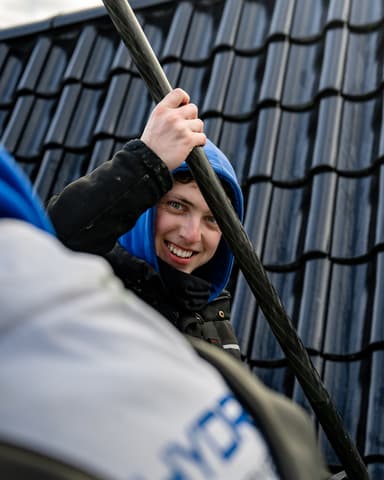 Hoogwerker bij wooncomplex voor reinigen daklijsten in Oostvoorne door Hydro Groep