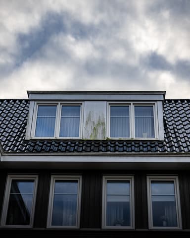 Vakman reinigt kozijn onderzijde met stoom op balkon in Oostvoorne door Hydro Groep