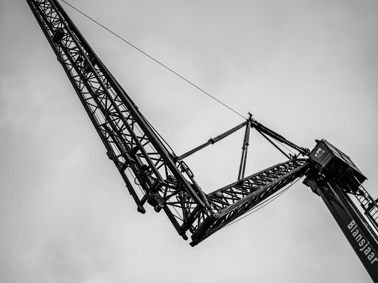 Detail hijskraan tegen bewolkte lucht bij steigerbouw in Rochussenstraat Rotterdam
