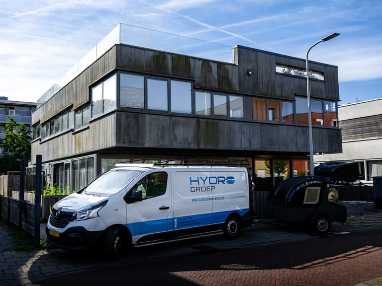 Hydro Groep bus bij woning met betonvezel gevelbeplating voor VvE Biancaland in Den Haag