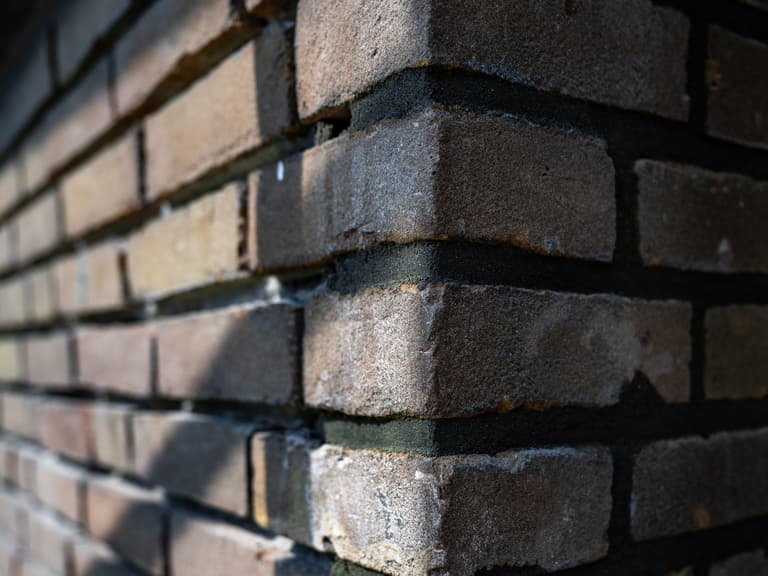 Woning met steiger en blauw gaas aan voorgevel voor conserveren metselwerk in Dordrecht