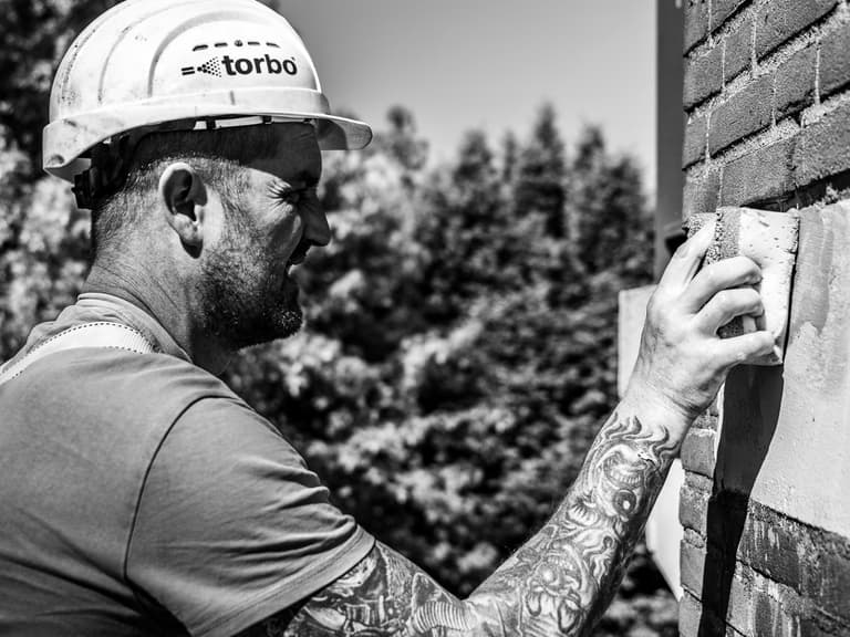 Meulemansflat met groene hoogwerker voor betonreparatie kopgevel in Tilburg door Hydro Groep